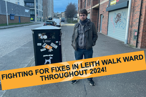 Cllr Jack Caldwell standing next to a full litterbin