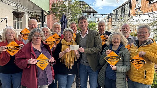 A group of Bridport & Chesil Bank Liberal Democrat Candidates and Councillors stood with Edward Morello stood outside the Bull Hotel holding 'Liberal Democrats Winning Here' window posters.