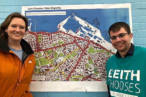 Councillors Sanne Dijkstra-Downie and Jack Caldwell stand in front of a map of the Leith Chooses Boundary