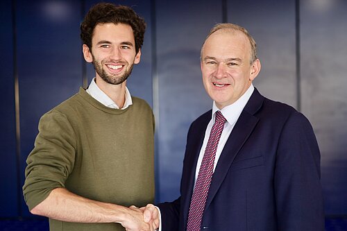 Will Aczel and Ed Davey shake hands