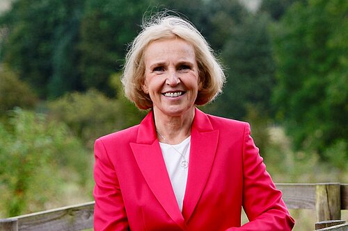 Susan Murray standing behind a fence