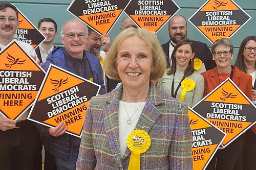 Susan Murray, MP for Mid Dunbartonshire, with activists behind holding orange diamonds.