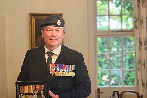 Richard Streatfeild holding his father's WWII medals