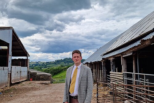 David Chadwick MP standing in front of farm in Brecon