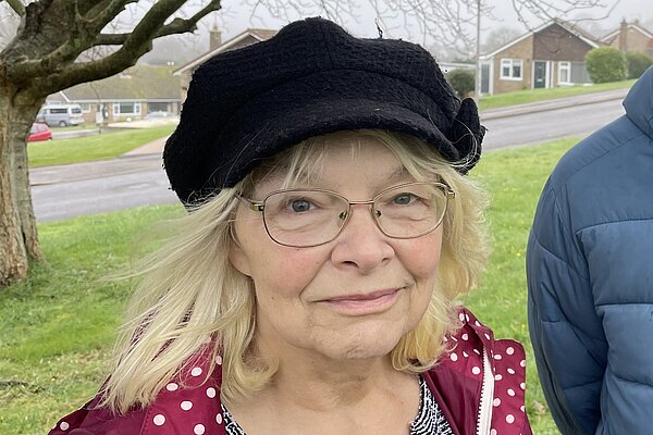 Anne Rickard, wearing a black beret, black and white top, and pink jacket. She is stood with Andy Holdridge, wearing a Blue puffer jacket.