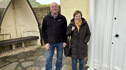 Dave Bolwell, in a black puffer jacket and jeans, and Ann Langridge, in a burgundy jacket with jeans and yellow scarf, stood outside of the West Bay Discovery Centre in West Bay