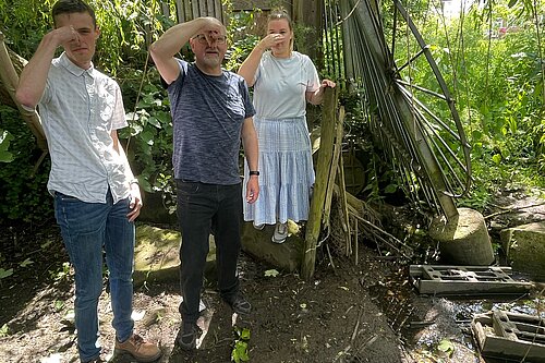 Hull Road campaigners standing in front of the Hull Rd sewage outflow, holding their noses