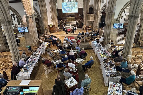 Holy Trinity Church Hurstpierpoint with people around tables and a Q&A session ongoing